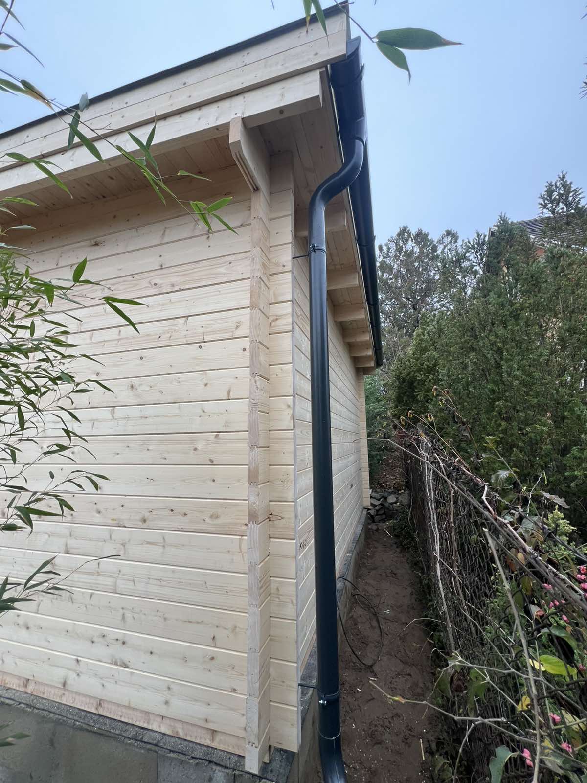 Holzhaus mit Regenwasserablauf